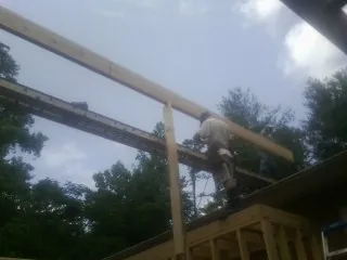 Carpenter setting a ridge beam over a new addition frame — Ice Dam Removal by Roofing Brothers in Madisonburg