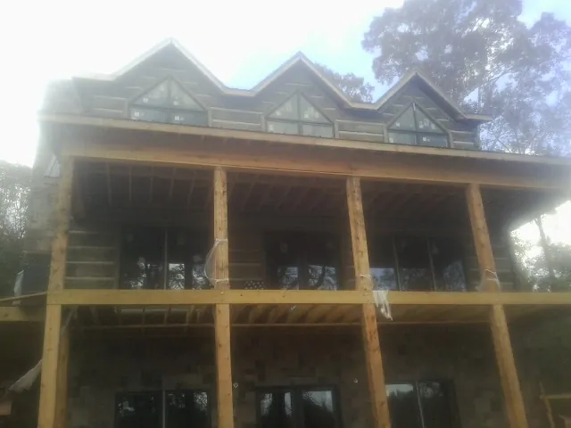 Dormers and porch framing on a large log home under construction — Roof Coating work by our crew in Madisonburg