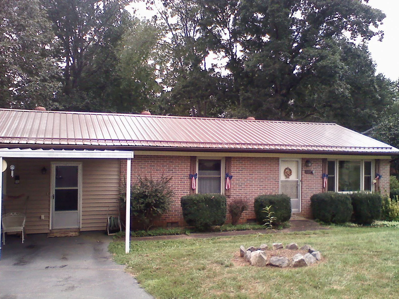Bronze metal roof and carport on a brick ranch home — Roof Repair work by our crew in Madisonburg